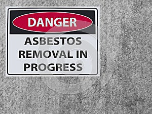 The sticker Sign danger asbestos removal on the plaster asbestos wall