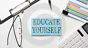 Stickers with chart,calculator and paper with text EDUCATE YOURSELF on the white background