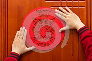 Sticking Chinese New Year of tiger 2022 mascot to the door translation of the Chinese is happy new tiger year