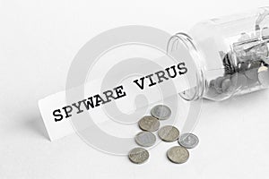 Sticking out of a jar of coins a piece of paper with a text Spyware virus on a white background