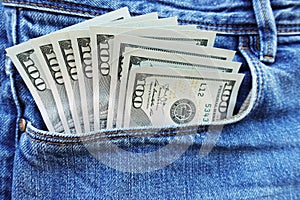 Sticking out money from blue jeans pocket, spending money concept