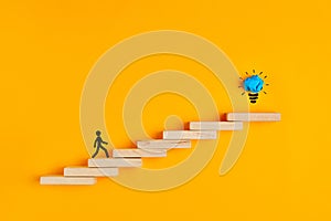 Stickman climbing steps towards the light bulb. Concept of success, creativeness or idea formation