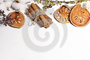 Sticks of cinnamon reknitted by twine, matum and cotton on a white background