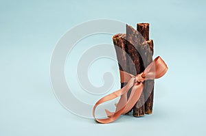 Sticks of dried beef esophagus on a turquoise background