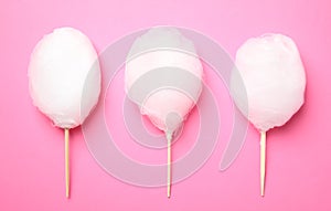 Sticks with yummy cotton candy on color background