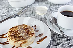 Sticky chocolate sauce on a freshly toasted crumpet with coffee