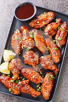 Sticky hoisin chicken wings with sauce closeup on the plate. Vertical top view