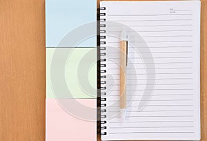 sticky note, ballpoint pen, empty notebook on office desk. business, education concept. Top view with copy space. selective focus.