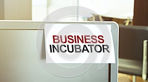 Sticky note on the computer. Text BUSINESS INCUBATOR