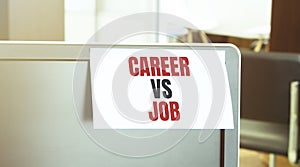 Sticky note on the computer. Text CAREER VS JOB