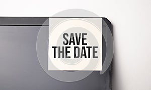 Sticky note on the computer. Text Save the Date