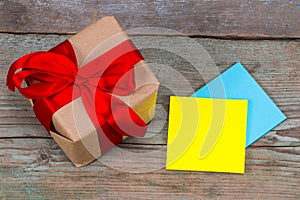 Sticky note with empty space for a text and gift with red ribbon