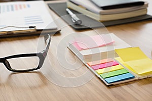 sticky note, eyeglasses, notebook on office desk. business, work