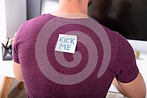 Sticky Note With Kick Me Text On Man`s Back