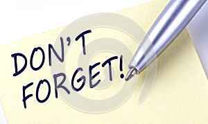 Sticky Note Message DON`T FORGET with pen on white background