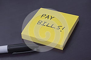 Sticky note pad with the reminder to pay bills photo