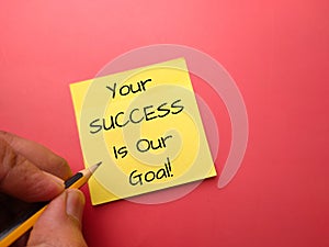 Sticky note and pencil with the word YOUR SUCCESS IS OUR GOAL
