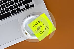 Sticky note with phrase Happy Boss Day attached to cup of coffee, flat lay.