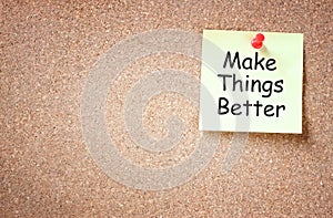 Sticky note pinned to cork board with the phrase make things better written on it room for text