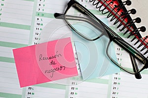 Sticky note and eyeglasses on a calendar photo