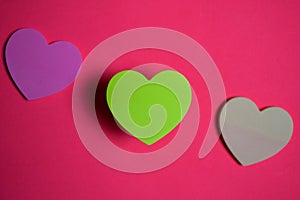 Sticky note shaped a heart symbol on pink background