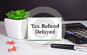 Sticky note with the text Tax Refund Delayed on Income Tax form background