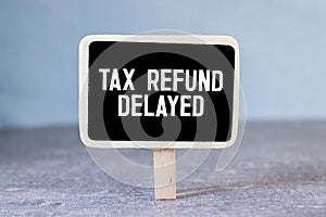 Sticky note with the text Tax Refund Delayed on Income Tax form background with calculator