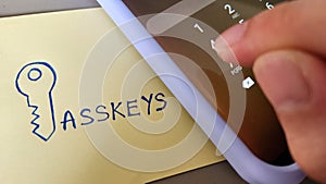 A sticky note with the word Passkeys placed beside a mobile phone