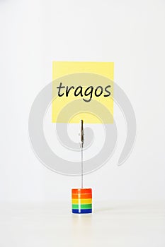 Sticky notepaper with Spanish text Tragos (Drinks) clipped to a multicolored card holder