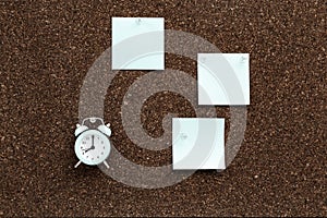 Sticky notes hanging and clock on cork board. Back to school concept