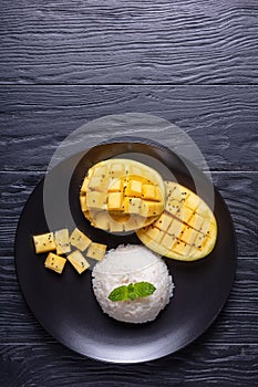 Sticky Rice With Mango on a black plate