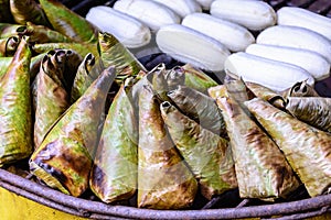 Sticky rice wrapped with banana leaf and banana grilling on stove