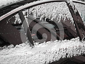 Sticky wet snow on car window and door with reflection