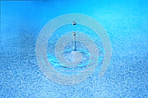 Stiffened water drop falling on a water surface