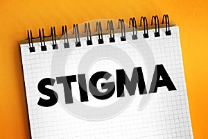 Stigma - a mark of disgrace associated with a particular circumstance, quality, or person, text concept on notepad