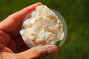 Stilbite crystal from India held in a hand photo