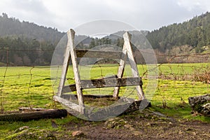 A stile over a fence in farm field