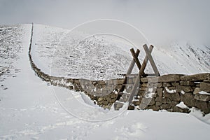 Stile over a stone wall in a snowy landscape