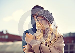 Stilish couple walking in modern hoodie sweatshirts and trendy hats  on autumn city old buildings background