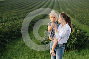 Stilish mother and daughter having fun on the nature. Happy family concept. Beauty nature scene with family outdoor