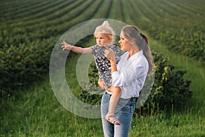 Stilish mother and daughter having fun on the nature. Happy family concept. Beauty nature scene with family outdoor