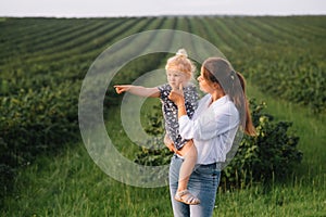 Stilish mother and daughter having fun on the nature. Happy family concept. Beauty nature scene with family outdoor