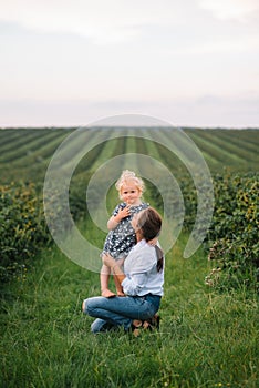 Stilish mother and daughter having fun on the nature. Happy family concept. Beauty nature scene with family outdoor