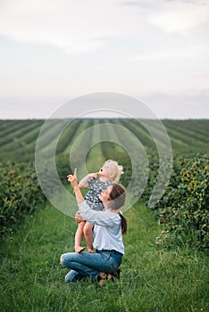Stilish mother and daughter having fun on the nature. Happy family concept. Beauty nature scene with family outdoor lifestyle.