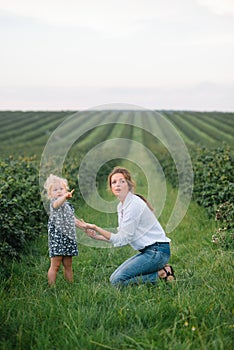 Stilish mother and daughter having fun on the nature. Happy family concept. Beauty nature scene with family outdoor lifestyle.