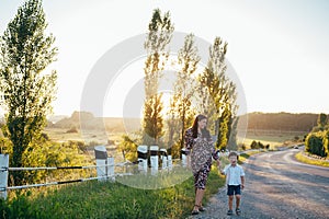 Stilish mother and handsome son having fun on the nature. Happy family concept. Beauty nature scene with family outdoor