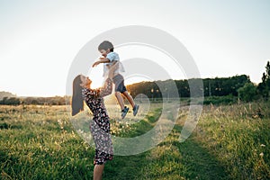 Stilish mother and handsome son having fun on the nature. Happy family concept. Beauty nature scene with family outdoor