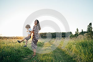 Stilish mother and handsome son having fun on the nature. Happy family concept. Beauty nature scene with family outdoor