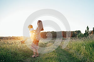 Stilish mother and handsome son having fun on the nature. Happy family concept. Beauty nature scene with family outdoor