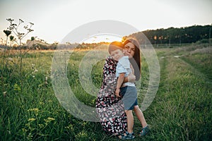 Stilish mother and handsome son having fun on the nature. Happy family concept. Beauty nature scene with family outdoor